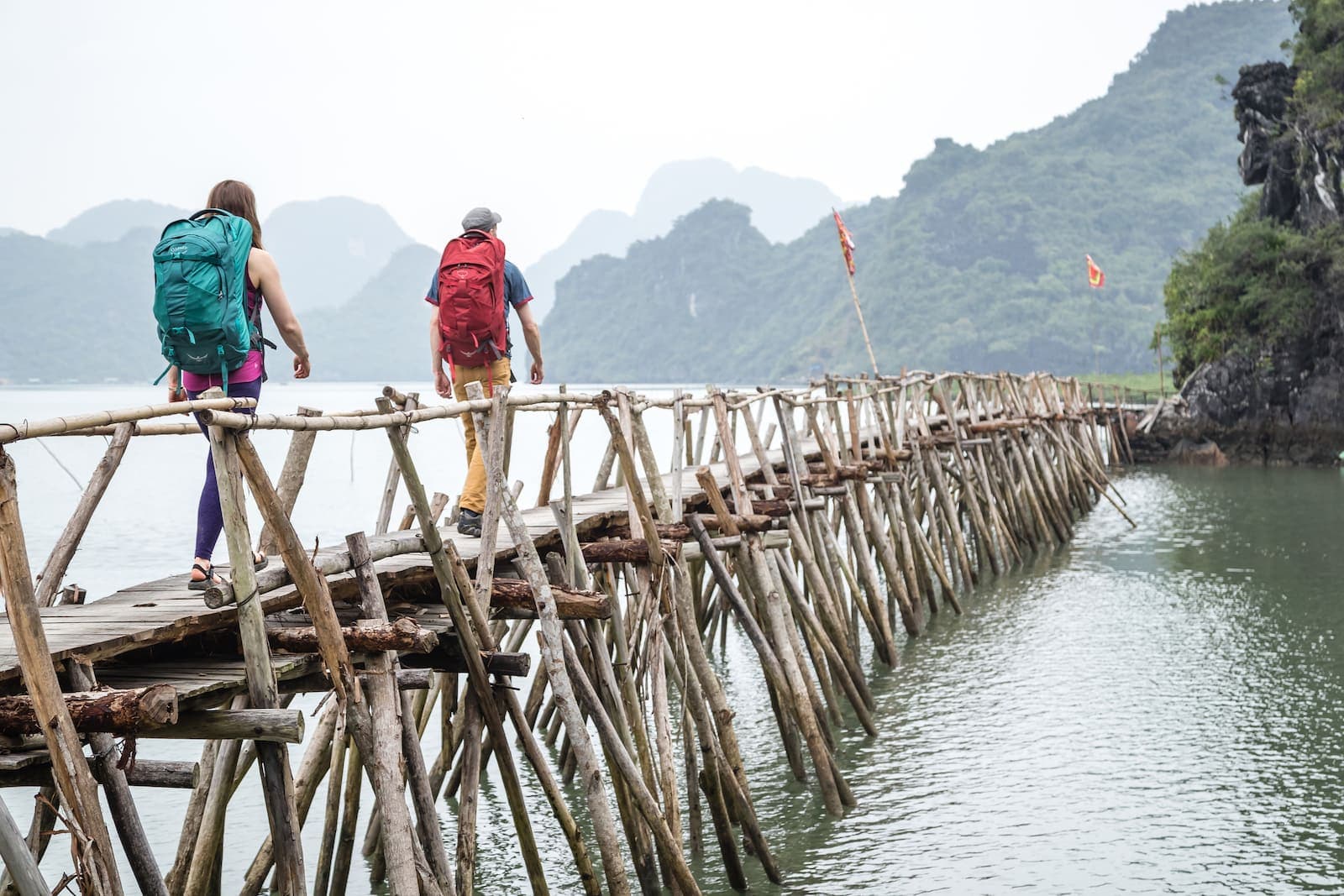 Eric Elofson and Ashley Buttelmann trek along a pier in Cat Ba National Park, Vietnam